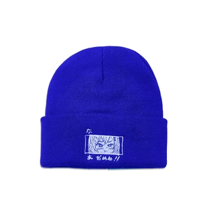 Detail of blue knit beanie featuring white anime eye embroidery and Japanese text