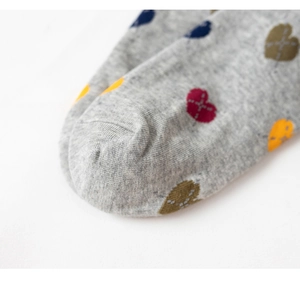 Close-up of grey cotton knit fabric featuring colorful heart patterns on the sock toe