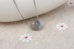 Macro shot of natural labradorite pendant with blue sheen on a silver chain necklace