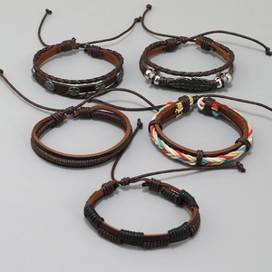 Detail shot of five-piece set vintage woven leather bracelets with alloy charms