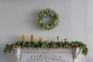 Detail of floral spring wreath and matching garland on a white fireplace mantel