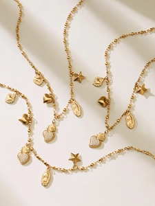 Close-up of layered gold beaded necklaces with heart, star, and religious pendants