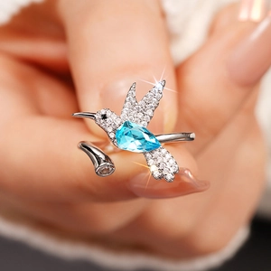 Detail van kolibrie ring met peervormige blauwe steen en pavé zetting in zilver