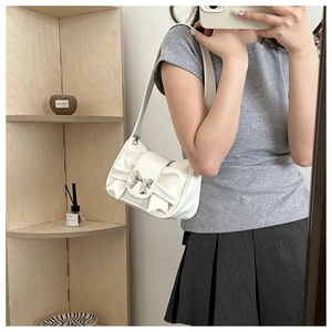 Selfie allo specchio con borsa a tracolla in pelle bianca con fiocco e fibbia in metallo