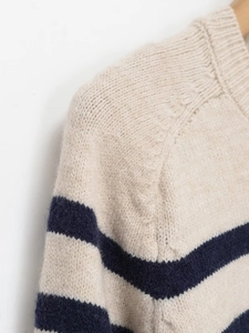 Close-up of crew neck striped knit sweater with soft wool texture and dropped shoulders