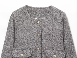 Gros plan sur la texture tweed grise et les boutons dorés décoratifs en relief