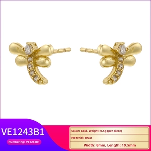 Macro shot of gold brass dragonfly stud earrings with sparkling white zircon crystals