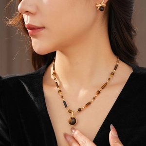 Close-up of elegant tiger eye stone necklace and earrings set on a model