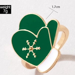 Macro detail of Christmas glove ring with green enamel and golden snowflake patterns
