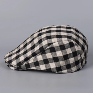 Détail de la casquette plate à carreaux noir et blanc montrant la texture du lin