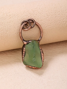 Macro detail of raw green fluorite pendant with vintage bronze metal edging