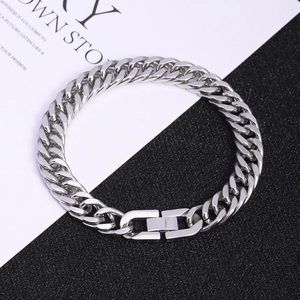 Silver stainless steel Cuban link bracelet with unique plug buckle on a dual-tone background