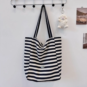 Detail of classic black and white striped canvas tote bag with Sozakka logo patch