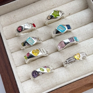 Close-up of S925 silver rings with colorful gemstone shapes in a velvet jewelry box