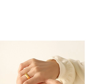 Close-up of minimalist gold teardrop ring with matte finish on a hand