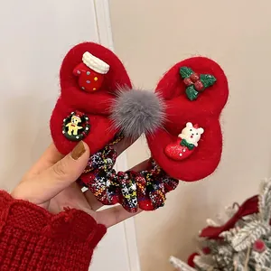 Detail of red festive bow hair scrunchie with Christmas ornaments and plaid pattern