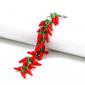 Detail view of red chili pepper keychain with glossy charms on a silver metal ring