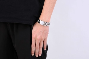 Detail shot of 20mm silver Cuban link chain bracelet with flat ID plate on male wrist