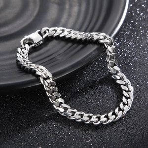 Detailed view of silver Cuban link chain bracelet with lobster clasp on dark tray