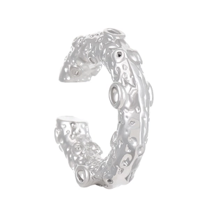 Macro detail of silver ear cuff featuring a textured lunar surface and crater design