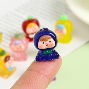 Luminous resin mini fruit figure in dark blue held on fingertip for DIY desk decor
