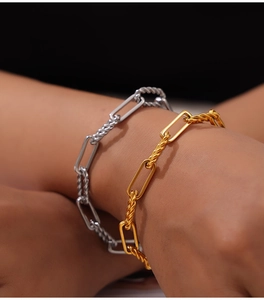 Close-up of gold and silver titanium steel bracelets with twisted paperclip chain link design