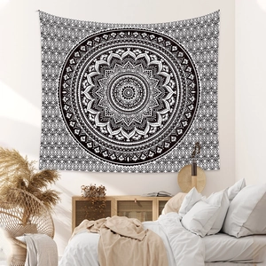 Detail of a black and white mandala tapestry in a cozy bohemian bedroom decor setting