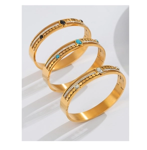 Three gold-plated steel bangles with hollow patterns and turquoise stone inlays