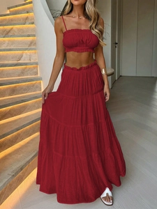 Detail of red two-piece vacation set featuring a strapless ruched top and tiered maxi skirt
