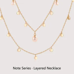 Double-layered gold necklace with shimmering metal sequins and freshwater pearls
