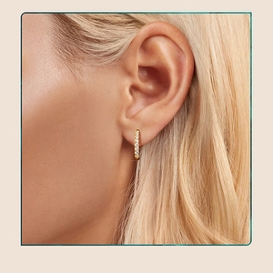 Close-up of elegant gold s925 silver hoop earrings with moissanite pavé on model
