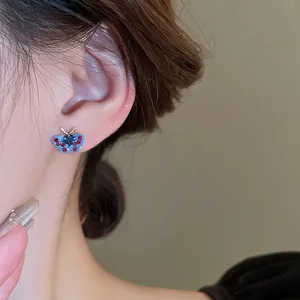 Blue butterfly stud earrings with rhinestones on model, sweet forest style design