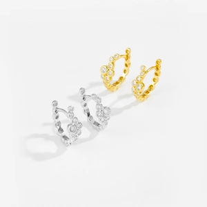 Close-up of S925 sterling silver earrings with inlaid white zircons in gold and silver