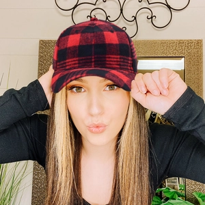 Detail of red and black buffalo plaid baseball cap with warm flannel texture on model