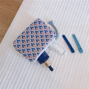 Gros plan sur la mini pochette en jacquard avec motifs géométriques bleus et orange