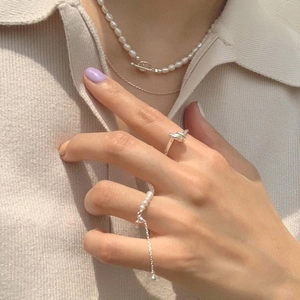Elegant 925 sterling silver woven ring set with pearls worn by a model in minimalist style