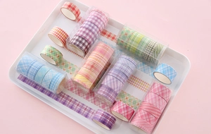 Macro shot of 50 colorful plaid washi tape rolls neatly organized in a tray for DIY craft