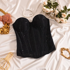 Close-up of black sequined corset top with silver glitter stripes on silk background