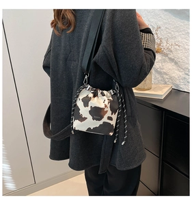 Dettaglio della borsa a secchiello maculata con coulisse e tracolla in nylon intrecciato