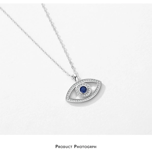 Macro detail of S925 silver Evil Eye necklace with blue gemstone and pavé stones