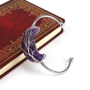 Silver wire wrapped moon bracelet with purple amethyst stone on vintage book