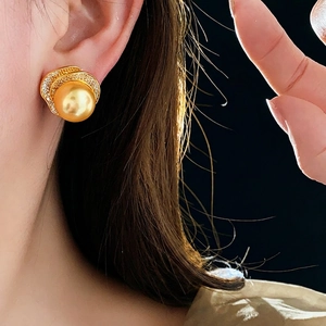 Elegant gold earrings with yellow pearls and sparkling crystals on model ear