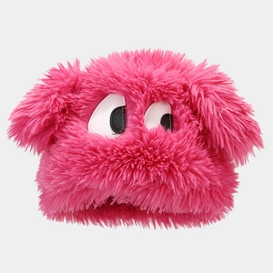 Close-up of bright pink plush faux fur winter hat with cute cartoon big eye embroidery
