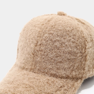 Detailed close-up of thick sherpa fleece fabric on a winter camel baseball cap