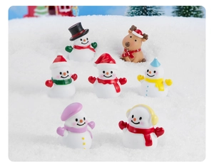 Statuine natalizie in resina con pupazzi di neve e renne su un display effetto neve