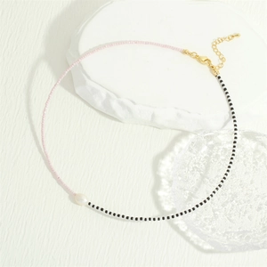 Detail of pink and black MGB glass beads necklace with a natural freshwater pearl pendant