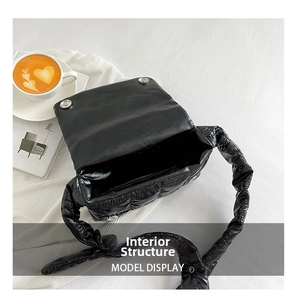 Close-up of internal structure of a black quilted puffer bag with magnetic flap closure