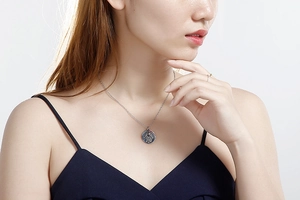 Detailed close-up of a silver Hamsa Hand engraved circular pendant necklace for women