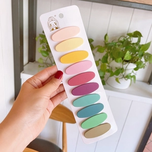 Detail of 10-piece matte colorful snap hair clips set displayed on a white brand card