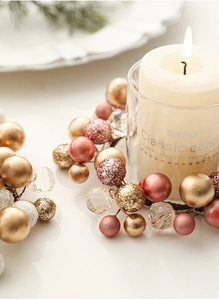 Detail of Christmas candle wreath with gold and pink metallic beads and crystal accents
